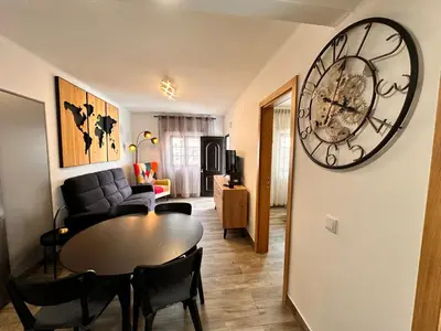 a living room with a table and a large clock on the wall at Casa da Ribeira in Vila do Bispo
