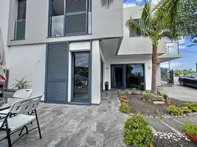 a house with a patio with a table and chairs at Gertrudes Dream House in Ponta do Sol