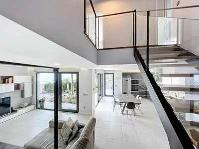 a living room with a staircase and a dining room at Gertrudes Dream House in Ponta do Sol