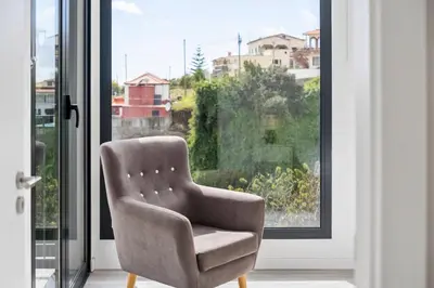 a chair sitting in front of a window at Calheta Sunsets in Estreito da Calheta