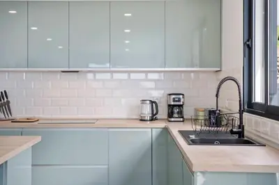 a kitchen with white cabinets and a sink at Calheta Sunsets in Estreito da Calheta