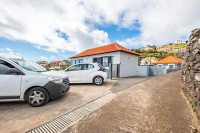 two cars parked in front of a house at Calheta Sunsets in Estreito da Calheta