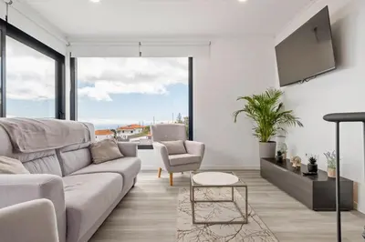 a living room with a couch and a tv at Calheta Sunsets in Estreito da Calheta