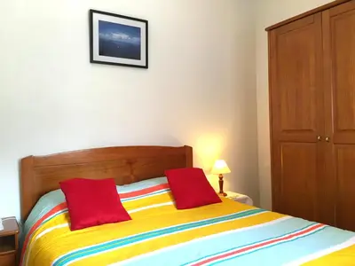 a bedroom with a colorful bed with two red pillows at Holidays Madeira in São Vicente
