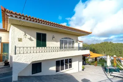 a white house with a balcony and a patio at GuestReady - Quinta das Estrelas in Campanário