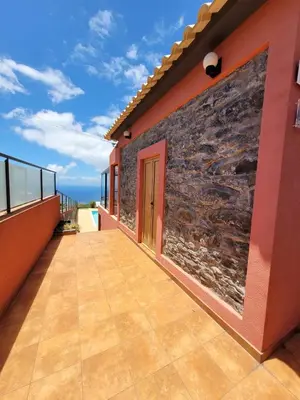 a balcony of a house with a brick wall at Sunset Paradise Villa with Heated Pool in Calheta
