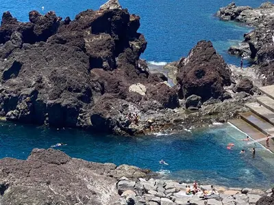 a group of boats in a body of water at Maria's House in Câmara de Lobos