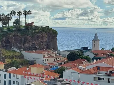 a group of people on a beach in the water at Maria's House in Câmara de Lobos