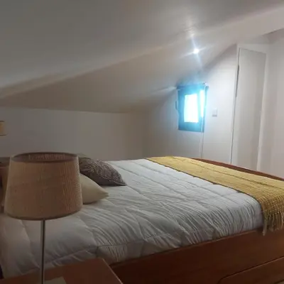 a bedroom with a bed with a green and white blanket at Maria's House in Câmara de Lobos