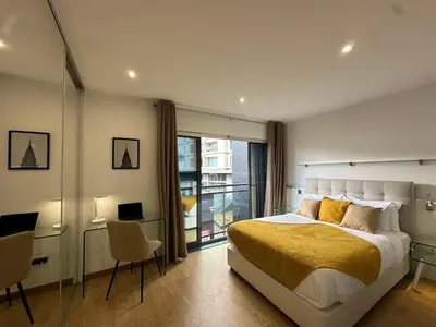 a bedroom with a large bed and a balcony at Living Funchal V in Funchal