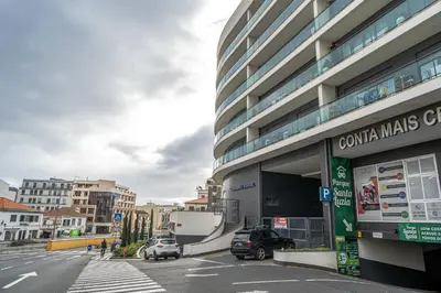 a city street with cars parked in front of a building at Living Funchal V in Funchal