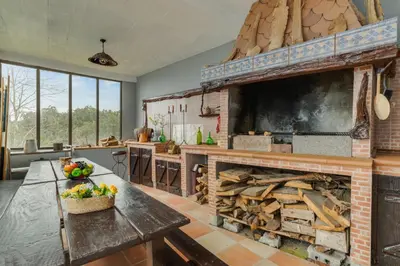 a kitchen with a large fireplace and a table with a bowl of fruit at Sa Dias House by AH in São Jorge