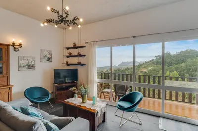a living room with a couch and chairs and a large window at Sa Dias House by AH in São Jorge