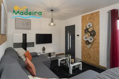 a living room with a couch and a tv at OurMadeira - VistaSerena in Raposeira do Logarinho