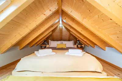 a bed in the attic of a house at Salsa Country House I I I in Porto Moniz