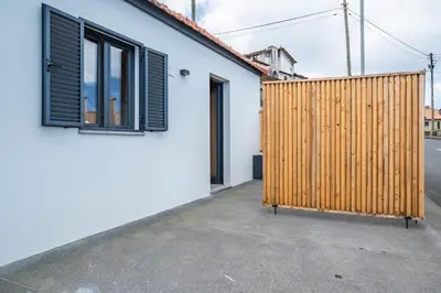 a wooden fence next to a white house at Salsa Country House I I I in Porto Moniz