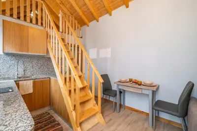 a staircase in a kitchen with a table and chairs at Salsa Country House I I I in Porto Moniz
