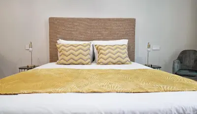 a bed with a yellow comforter and two pillows at Daysy Loft by LovelyStay in Funchal
