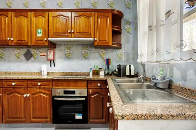 a kitchen with wooden cabinets and a sink at Pico The Best View in Ribeira Brava