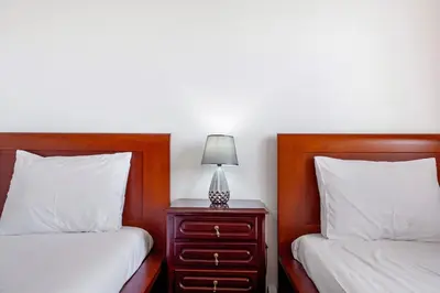 a bedroom with two beds and a nightstand with a lamp at Pico The Best View in Ribeira Brava