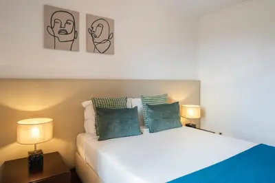 a bedroom with a white bed with two lamps at Vila Esperança by An Island Apart in Calheta