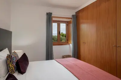 a bedroom with a bed and a window at Vila Esperança by An Island Apart in Calheta