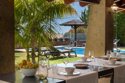 a restaurant with a table with food and a pool at Vila Esperança by An Island Apart in Calheta