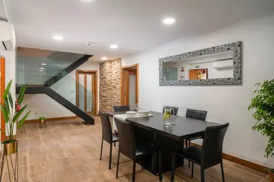 a dining room with a black table and chairs at Vila Esperança by An Island Apart in Calheta