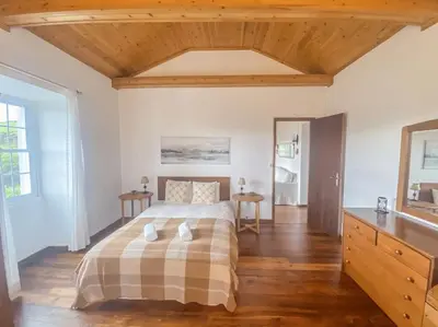 a bedroom with a bed and a wooden floor at Sun Island Retreat - Great Sunny Island Sea view in Vila do Porto