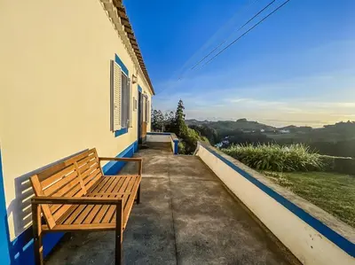 a wooden bench sitting on the side of a building at Sun Island Retreat - Great Sunny Island Sea view in Vila do Porto