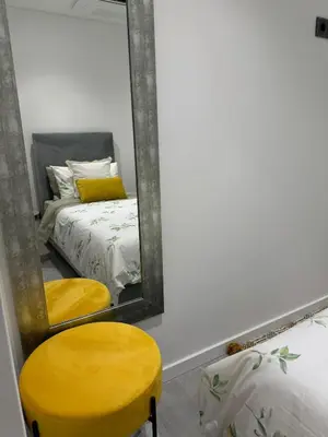 a bedroom with a mirror and two yellow chairs at Quinta da Oliveira in Ponta do Sol
