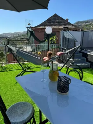 a little girl sitting in a hammock on a table at Quinta da Oliveira in Ponta do Sol
