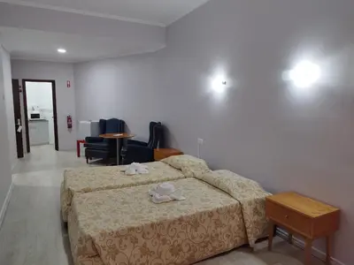 a bedroom with a bed and chairs and a table at Alojamento Central II in Funchal