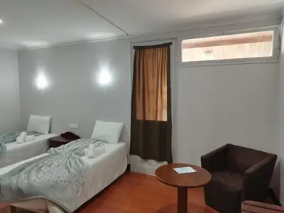 a bedroom with a bed and a chair and a window at Alojamento Central II in Funchal