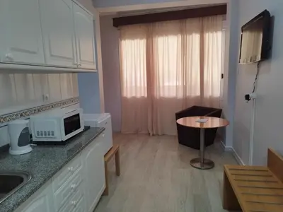 a kitchen with a microwave and a small table at Alojamento Central II in Funchal