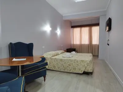 a hotel room with a bed and a table and chairs at Alojamento Central II in Funchal