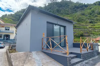 a blue house with a mountain in the background at GuestReady - A lovely refuge in Madeira in Machico