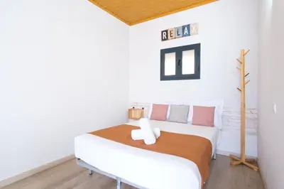 a white bedroom with a white bed with orange and pink pillows at GuestReady - A lovely refuge in Madeira in Machico