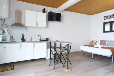 a kitchen with a table and a bed in a room at GuestReady - A lovely refuge in Madeira in Machico