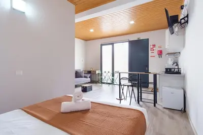 a bedroom with a bed and a living room with a kitchen at GuestReady - A lovely refuge in Madeira in Machico