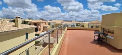 a balcony with a table on the roof of a building at Casa Riomara in Lagos