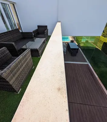 a backyard with a deck and a table and chairs at White Beach Villa in Sagres