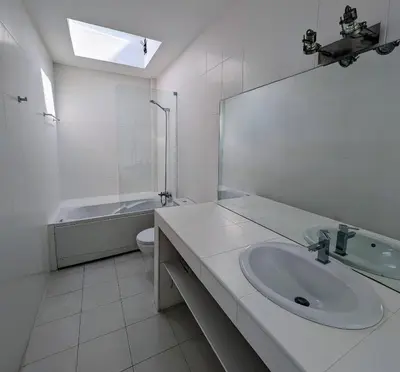 a white bathroom with a sink and a bath tub at White Beach Villa in Sagres