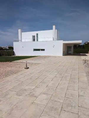 a white house with a large driveway in front of it at White Beach Villa in Sagres
