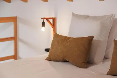 a bed with two pillows on top of it at Mountain Chalet by Lavibes in São Vicente