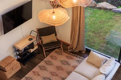 a living room with a couch and a chair and a large window at Mountain Chalet by Lavibes in São Vicente