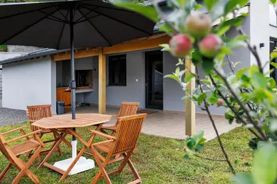 a wooden table and chairs with an umbrella at Mountain Chalet by Lavibes in São Vicente