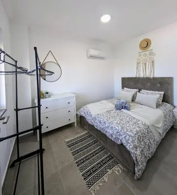 a bedroom with a bed and a dresser in it at Apartamento da Praia in Sagres