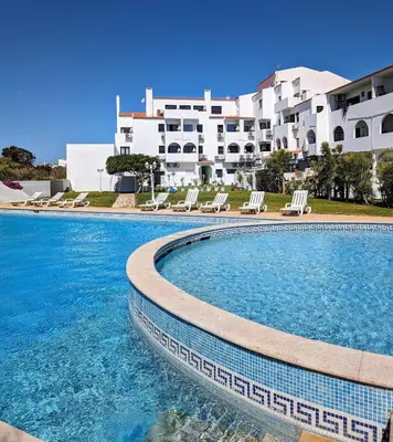 a swimming pool in front of a building at Apartamento da Praia in Sagres