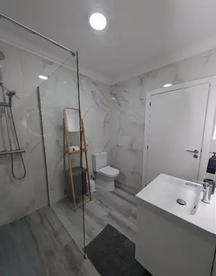 a bathroom with a shower and a sink and a toilet at Apartamento da Praia in Sagres
